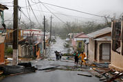 Rescue workers help people on Sept. 20 in Guayama, Puerto Rico, after the area was hit by Hurricane Maria. After battering the Virgin Islands, the hurricane made landfall in Puerto Rico, bringing "catastrophic" 155 mph winds and dangerous storm surges. (CNS photo/Carlos Garcia Rawlins, Reuters)