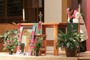 Father Joe Townsend, pastor of St. Benedict Parish in Broken Arrow, Okla., bows before the altar and an image of Father Stanley Rother during a Sept. 22 vespers and vigil