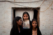 The daughters of Asia Bibi pose in 2010 with an image of their mother outside their residence in Sheikhupura, Pakistan. (CNS photo/Adrees Latif, Reuters) 