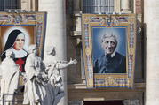 Banners showing new Sts. Giuseppina Vannini and John Henry Newman hang from the facade of St. Peter's Basilica as Pope Francis celebrates the canonization Mass for five new saints in St. Peter's Square at the Vatican Oct. 13, 2019. (CNS photo/Paul Haring)