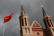 07.21.2020 The Chinese national flag flies in front of a Catholic church in Huangtugang, China, in this 2018 photo. As the Vatican-China agreement on the naming of bishops approaches two years, Beijing is still lagging behind in giving concessions compared with those made ahead of the deal by the Vatican. (CNS photo/Thomas Peter, Reuters)