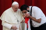 A masked Maronite Father Georges Briedi kisses the hand of Pope Francis as the two men hold a Lebanese flag during the pope's weekly general audience at the Vatican Sept. 2, 2020. (CNS photo/Guglielmo Mangiapane, Reuters)
