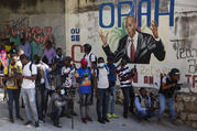 Journalists gather near a mural featuring Haitian President Jovenel Moise, near the leader’s residence where he was killed by gunmen in the early morning hours, and his wife was wounded, in Port-au-Prince, Haiti, Wednesday, July 7, 2021. (AP Photo/Joseph Odelyn)