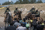 U.S. Customs and Border Protection mounted officers attempt to contain migrants as they cross the Rio Grande from Ciudad Acuña, Mexico, into Del Rio, Texas, Sunday, Sept. 19, 2021. Thousands of Haitian migrants have been arriving to Del Rio, Texas, as authorities attempt to close the border to stop the flow of migrants. (AP Photo/Felix Marquez)