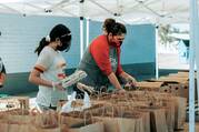 Volunteers at a food bank prepare groceries for distribution. (Photo by Ismael Paramo on Unsplash)