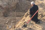 Cardinal Konrad Krajewski, the papal almoner, who is in Ukraine as a papal envoy, prays over a mass grave near Borodyanka, Ukraine, April 15, 2022. (CNS photo/Vatican Media)