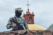 A member of the Mexican army stands guard outside St. Francisco Javier church in Cerocahui on June 22, 2022. Jesuit Fathers Javier Campos Morales and Joaquín César Mora Salazar were murdered at the parish on June 20 as they offered refuge to a tour guide seeking protection. (CNS photo/Reuters)