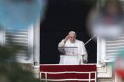 Pope Francis is framed by decorations on the Christmas tree as he leads the Angelus from the window of his studio overlooking St. Peter's Square at the Vatican.
