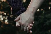 Two fair-skinned hands hold each other 