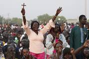 A woman raises a cross as people wait for the start of an ecumenical prayer service attended by Pope Francis at the John Garang Mausoleum in Juba, South Sudan, Feb. 4, 2023. (CNS photo/Paul Haring)