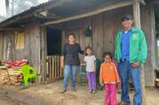 A family stands in front of their home in Honduras