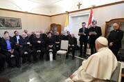 Several Jesuits, dressed in black cassocks, sit across from Pope Francis, who is on the right side of the frame, at the apostolic nunciature in Hungary.