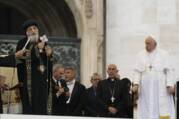 Roman Catholic and Coptic Orthodox priests stand on a stage 