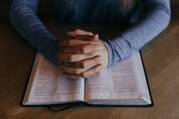 Man holding hands on Bible