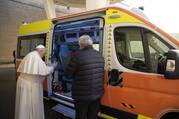 The pope stands in front of an ambulance that will go to Ukraine, blessing it. 