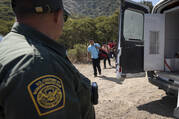 A Border Patrol agent leads a group of migrants seeking asylum toward a van to be transported and processed on June 5, 2024, near Dulzura, Calif. (AP Photo/Gregory Bull)