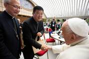 Bishop Joseph Yang Yongqiang of Hangzhou, China, shakes hands with Pope Francis while Bishop Vincent Zhan Silu of Funing-Mindong, the other member of the Synod of Bishops from mainland China, looks on in the Paul VI Audience Hall 