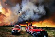 Firefighters stand on a Kamloops Fire Rescue truck at a wildfire near Fort St. John, British Columbia, May 14, 2023. Wildfires have always occurred, but experts say the warming climate is increasing their severity. (OSV News photo/Kamloops Fire Rescue handout via Reuters)