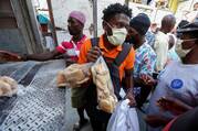 People accept food distributed from a truck by a Haitian government program in Port-au-Prince, Haiti, April 6, 2020, amid the coronavirus (COVID-19) pandemic. The U.S. Conference of Catholic Bishops and other faith groups then were urging the Trump administration to support debt relief for poor nations. (CNS photo/Jeanty Junior Augustin, Reuters)