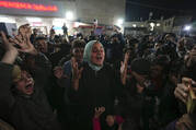 Palestinians celebrate the announcement of a ceasefire deal between Hamas and Israel in Deir al-Balah, central Gaza Strip, Wednesday, Jan. 15, 2025. (AP Photo/Abdel Kareem Hana)
