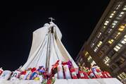 Votive candles and flowers are seen at the base of a statue of St. John Paul II outside Rome's Gemelli hospital Feb. 21, 2025, where Pope Francis is being treated for double pneumonia. (CNS photo/Pablo Esparza)