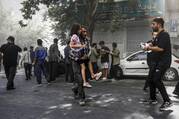 A man carries a wounded girl after an explosion in downtown Tehran amid Israel's three-day campaign of strikes against Iran, Sunday, June 15, 2025. (AP Photo/Morteza Zangene/ISNA)