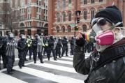 A protester faces off with a line of riot police during a demonstration after the inauguration of President Donald Trump, Friday, Jan. 20, 2017, in Washington. (AP Photo/John Minchillo)