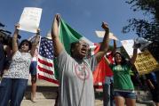 Counterprotesters hold signs and chant at the Statehouse before a planned "Free Speech" rally by conservative organizers begin on the adjacent Boston Common, Saturday, Aug. 19, 2017, in Boston. (AP Photo/Michael Dwyer)