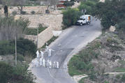 Forensic police work on the main road in Bidnija, Malta, which leads to Daphne Caruana Galizias house, looking for evidence on the blast that killed the journalist as she was leaving her home, Thursday, Oct. 19, 2017. Caruana Galizia, a harsh critic of Maltese Premier Joseph Muscat, and who reported extensively on corruption on Malta, was killed by a car bomb on Monday. (AP Photo/Rene Rossignaud)