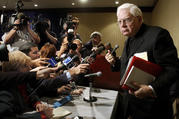 In this Tuesday, Nov. 12, 2002 file photo, Cardinal Bernard Law, right, departs a news conference during the second day of the U.S. Conference of Catholic Bishops annual meeting in Washington (AP Photo/Ken Lambert, File).