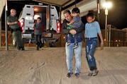 A Honduran man carries his 3-year-old son as his daughter and other son follow to a transport vehicle after being detained by U.S. Customs and Border Patrol agents in San Luis, Ariz., on July 18. Federal judges in California have challenged more of the Trump administration's "zero-tolerance" policy on illegal immigration. (AP Photo/Matt York, File)