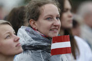 A young woman holds the Latvian flag as Pope Francis celebrates Mass Sept. 24 at the Shrine of the Mother of God in Aglona, Latvia. (CNS photo/Paul Haring) 