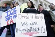 Protesters hold signs as they listen to speakers at a rally outside of City Hall in San Francisco, Wednesday, Jan. 25, 2017. President Donald Trump moved aggressively to tighten the nation's immigration controls Wednesday, signing executive actions to jumpstart construction of his promised U.S.-Mexico border wall and cut federal grants for immigrant-protecting "sanctuary cities." (AP Photo/Jeff Chiu)