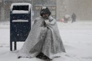 A homeless man asks for money during blizzard-like conditions Feb. 9 in in Boston (CNS photo/Brian Snyder, Reuters).