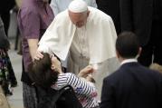 Pope Francis caresses a sick woman during an audience with Huntington's disease sufferers and their families, in the Paul VI Hall, at the Vatican on Thursday, May 18, 2017. (AP Photo/Andrew Medichini)