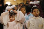 Children dressed as angels react as they attend Christmas Mass at Catholic church in Beijing, December 24. 