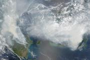 In this NASA image smoke rises from hundreds of active fires across Borneo and Sumatra.