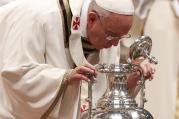 Pope Francis breathes over chrism oil, a gesture symbolizing the infusion of the Holy Spirit, during Holy Thursday chrism Mass in St. Peter's Basilica at the Vatican. 