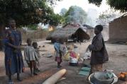 Women and children stand near their destroyed house in a village in Bossangoa, Central African Republic