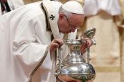 Pope Francis breathes over chrism oil, a gesture symbolizing the infusion of the Holy Spirit, during the Holy Thursday chrism Mass in St. Peter's Basilica at the Vatican, March 24 (CNS photo/Paul Haring).