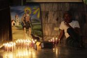 A worshipper smokes a cigar beside a painting in the shrine of St. Lazarus in the town of El Rincon, Cuba, in December 2013. (CNS photo/Desmond Boylan, Reuters)