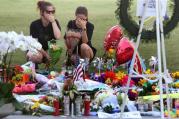 Kelli Cantu 24, left and Soe Aponte, 23, of Orlando become emotional Tuesday, June 14, 2016, as they visit a growing memorial at the The Dr. Phillips Center for the victims of the mass shooting at the Pulse Nightclub. (Red Huber/Orlando Sentinel via AP)