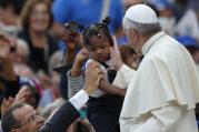 Pope Francis greets a child as he arrives to lead his general audience in St. Peter's Square at the Vatican Sept. 17. (CNS photo/Paul Haring)