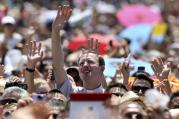Clergyman waves as Pope Francis leads Angelus at Vatican.