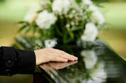 Close up of hand on coffin