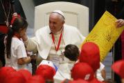 Pope Francis greets a girl after accepting a gift from her during a meeting with children of Italian prisoners in Paul VI hall at the Vatican May 30. (CNS photo/Paul Haring)