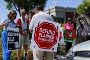 Protesters carry signs and an image of Our Lady of Guadalupe outside a Planned Parenthood clinic in Vista, Calif., Aug. 3 (CNS photo/Mike Blake, Reuters). 