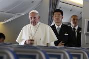 Pope Francis walks down aisle aboard flight from Seoul to Rome, August 18.