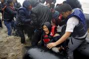 Afghan mother holds her baby as she struggles to disembark raft during a rainstorm in Lesbos, Greece, Oct. 23 (CNS photo/Yannis Behrakis, Reuters).