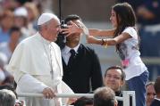 A young girl greets Pope Francis as he arrives in St. Peter's Square on Sept. 11